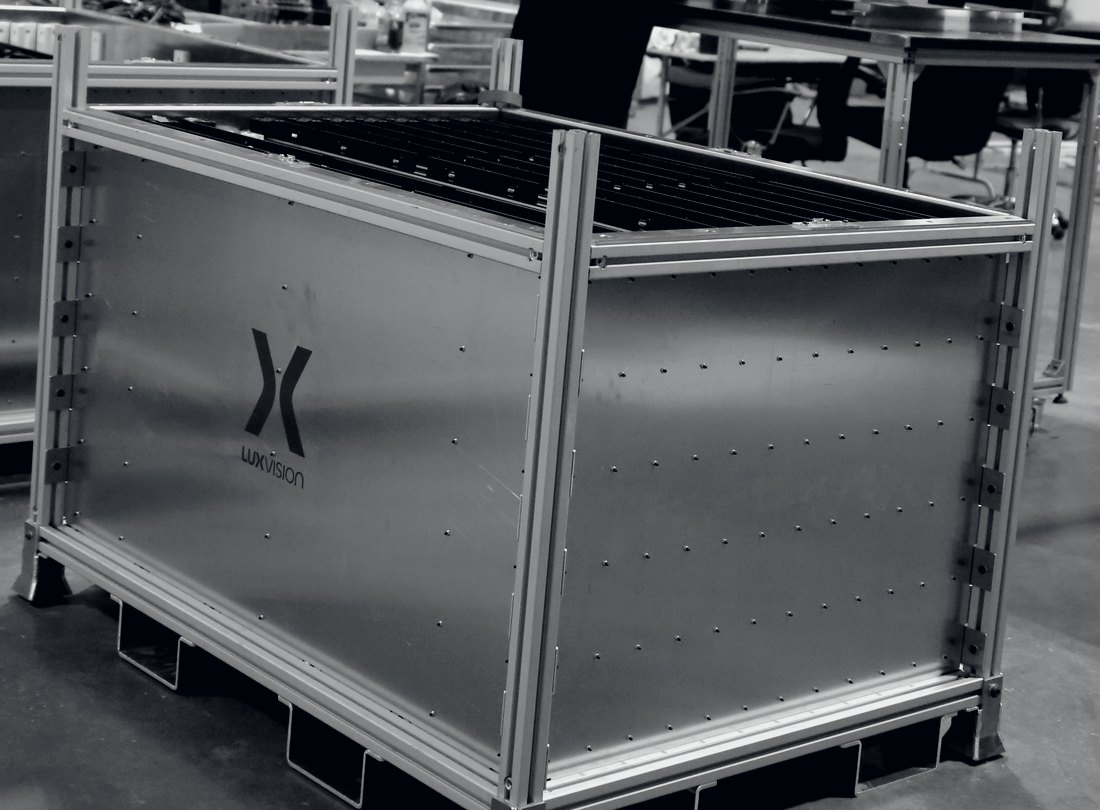 A LUXVISION shipping crate and cabinet frame on the warehouse floor in Edmonton, extruded aluminium uprights and a fitted module row